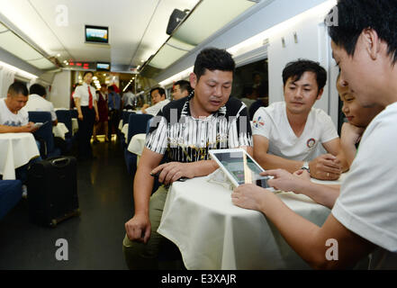 (140701)--Peking, 1. Juli 2014 (Xinhua)--Passagiere auf einem Hochgeschwindigkeitszug von Peking, die Hauptstadt von China, nach Xiamen, Südost-China Fujian Provinz, 1. Juli 2014 eine iPad kostenlos nutzen. Die neue Hochgeschwindigkeits-Eisenbahnstrecke zwischen Peking und Xiamen startete seinen Betrieb am Dienstag, schneiden die Fahrzeit zwischen den beiden Städten auf weniger als 13 Stunden. (Xinhua/Li er) (Ry) Stockfoto