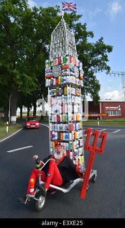 Storkow, Deutschland. 1. Juli 2014. Fahrrad-Designer Dieter "Didi" Senft ist in einem "Tour-Teufel" Kostüm gekleidet, als er seine neueste Kreation Fahrrad in Storkow, Deutschland, 1. Juli 2014 präsentiert. Er hat ein Fahrrad in der Form des Londoner Big Ben von 387 Trinkflaschen geschaffen. Der diesjährigen Tour de France startet am 5. Juli 2014. Senft arbeitet seit Jahren auf außergewöhnliche Motorrad Designs und zahlreiche Weltrekorde hält. Foto: PATRICK PLEUL/DPA/Alamy Live-Nachrichten Stockfoto