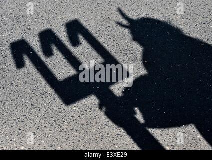 Storkow, Deutschland. 1. Juli 2014. Schatten der Fahrrad-Designer Dieter "Didi" Senft als er seine neueste Fahrrad-Kreation, gekleidet in ein "Tour-Teufel" Kostüm in Storkow, Deutschland, 1. Juli 2014 präsentiert. Er hat ein Fahrrad in der Form des Londoner Big Ben von 387 Trinkflaschen geschaffen. Der diesjährigen Tour de France startet am 5. Juli 2014. Senft arbeitet seit Jahren auf außergewöhnliche Motorrad Designs und zahlreiche Weltrekorde hält. Foto: PATRICK PLEUL/DPA/Alamy Live-Nachrichten Stockfoto