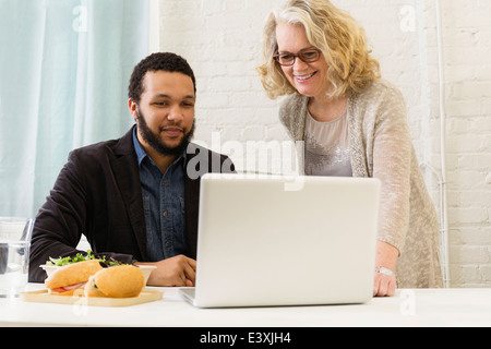 Geschäftsleute, die dem gemeinsamen Mittagessen im Büro Stockfoto