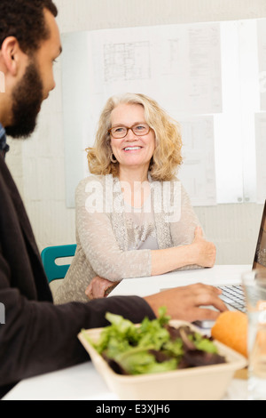 Geschäftsleute, die dem gemeinsamen Mittagessen im Büro Stockfoto