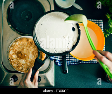 Frau macht Pfannkuchen in Küche Stockfoto