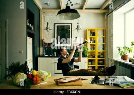 Kaukasischen Mann spielt Trompete in Küche Stockfoto