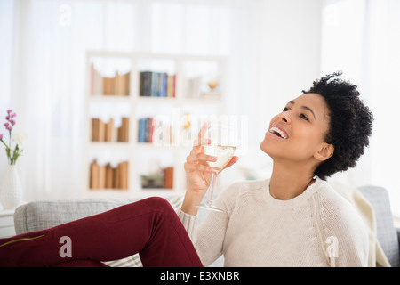 Schwarze Frau Weintrinken auf sofa Stockfoto