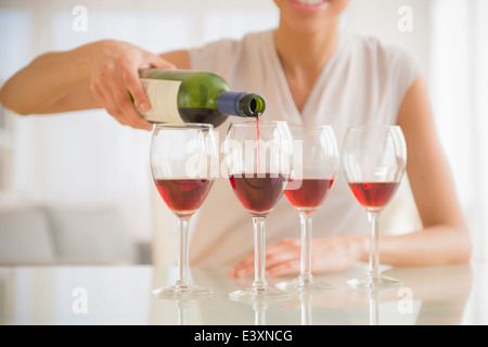 Schwarze Frau Gläser Wein gießen Stockfoto