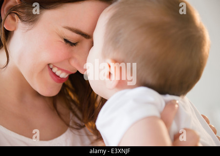 Lächelnde Mutter wiegt baby Stockfoto