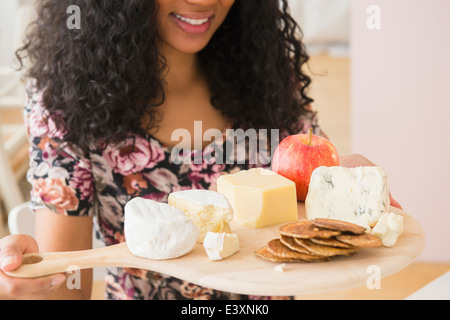 Gemischte Rassen Frau mit Obst und Käse-Brett Stockfoto