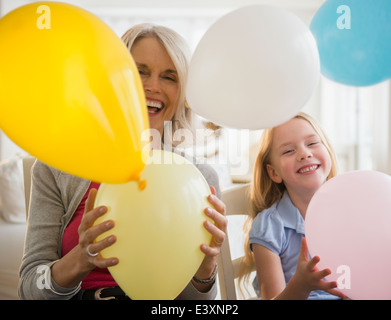 Senior kaukasischen Frau und Enkelin spielen mit Luftballons Stockfoto