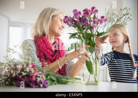 Senior-kaukasischen Frau und Enkelin Anordnen von Blumen Stockfoto