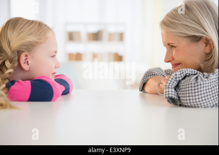Senior kaukasischen Frau und Enkelin am Tisch sitzen Stockfoto