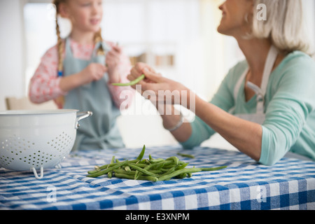 Senior kaukasischen Frau und Enkelin dem Entfernen Erbsen zusammen Stockfoto