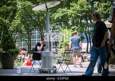 Ein Handy-Nutzer nutzt ein Handy und Tablet solar betriebene Ladestation im Bryant Park in New York Stockfoto