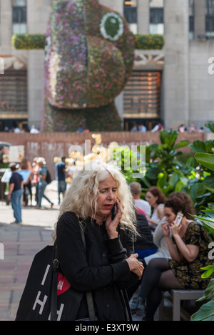 Frauen auf dem Handy am Ohr in den Kanal-Gärten im Rockefeller Center Stockfoto