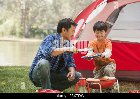 Vater und Sohn Kochen auf Campingplatz Stockfoto