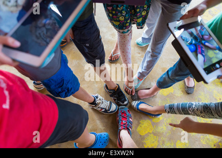 Kinder fotografieren Schuhe mit digitalen Tabletten Stockfoto