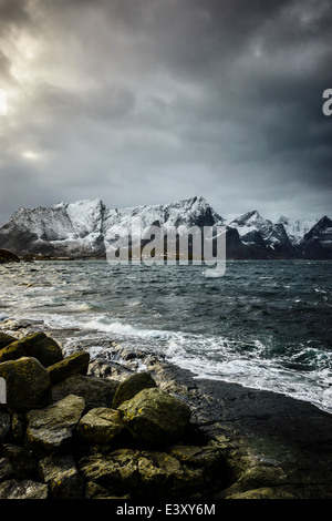 Schneebedeckte Berge, mit Blick auf die felsige Küste, Reine, Lofoten Inseln, Norwegen Stockfoto