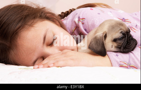 Gemischte Rassen Mädchen schläft mit Mops Stockfoto