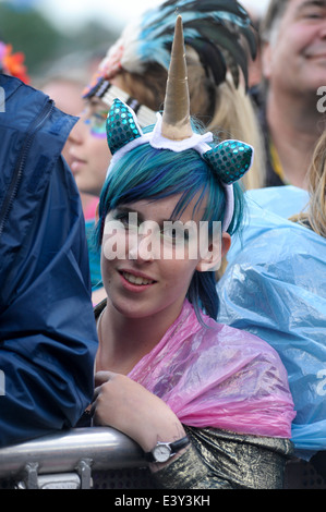 Pilton, UK, 27.06.2014: Glastonbury Festival. Eine junge Frau in der ersten Reihe des Publikums Einhorn Kostüm.  Bild von Julie Edwards Stockfoto