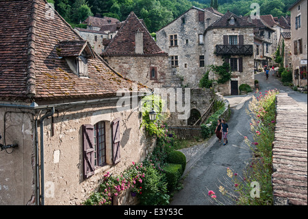 Touristen zu Fuß durch das mittelalterliche Dorf Saint-Cirq-Lapopie, Lot, Midi-Pyrénées, Frankreich Stockfoto