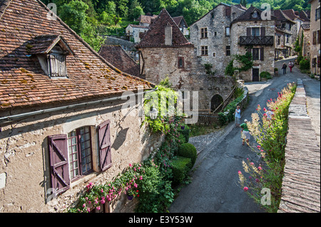 Touristen zu Fuß durch das mittelalterliche Dorf Saint-Cirq-Lapopie, Lot, Midi-Pyrénées, Frankreich Stockfoto