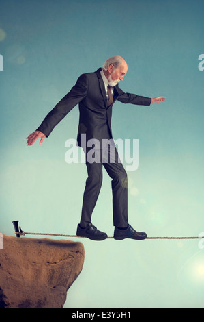 ältere Mann zu Fuß auf einem Drahtseil oder highwire Stockfoto