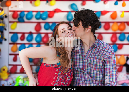 Romantisches Paar küssen auf die Wange am Messe-Stand Stockfoto