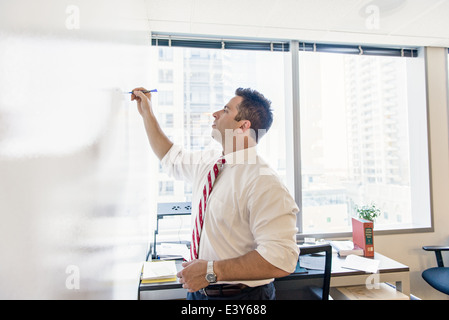 Wirtschaftsjurist schreibt am Whiteboard im Büro treffen Stockfoto