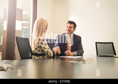 Männliche und weibliche Wirtschaftsanwälte Händeschütteln im Büro Stockfoto