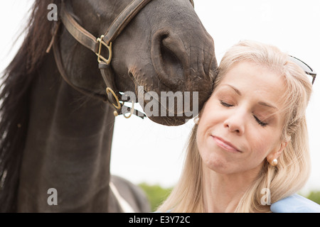 Nahaufnahme des Pferdes Reife Frau Gesicht berühren beschnitten Stockfoto