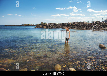 Junge Frau im Meer am felsigen Küste Strand in Biddeford, Maine, USA Stockfoto