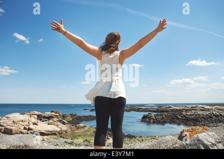 Rückansicht des jungen Frau am felsigen Küste Strand in Biddeford, Maine, USA Stockfoto