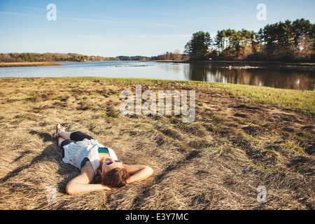 Junge Frau Sonnenbaden auf dem Rasen in Kittery, Maine, USA Stockfoto