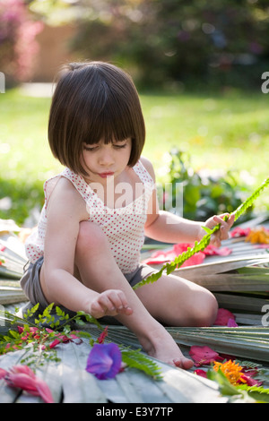 Mädchen mit Farn machen Blume und Blatt-Anzeige im Garten Stockfoto