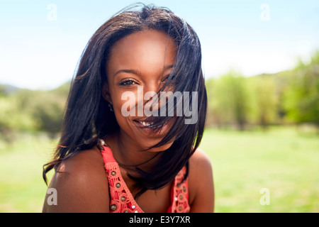 Porträt der jungen Frau mit Haaren, die über ihr Gesicht geblasen Stockfoto