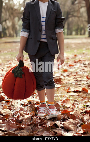 Bild eines jungen im Wald hält der Kürbiskopf beschnitten Stockfoto