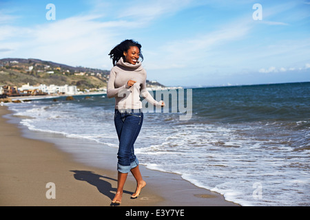 Junge Frau barfuß am Strand von Malibu, Kalifornien, USA Stockfoto