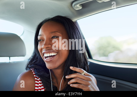 Junge Frau lachend Auto Rücksitz Stockfoto