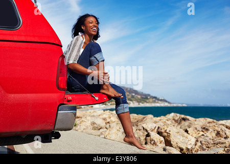 Junge Frau sitzt auf der Motorhaube, Malibu, Kalifornien, USA Stockfoto