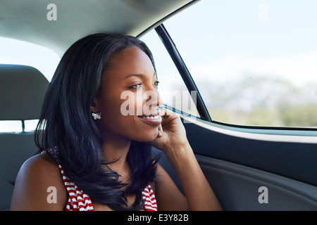 Porträt der jungen Frau blickte durch Autofenster Rücksitz Stockfoto