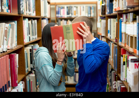 Junges Paar versteckt sich hinter Buch Stockfoto