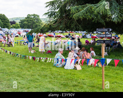 East Devon, England. Eine Fete und Gartenfest mit Menschen im Schatten der Bäume sitzen und in der Regel in der Sonne entspannen. Stockfoto