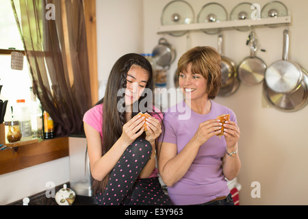 Mitte Erwachsene Frau und Teenager-Mädchen in Küche, Essen snack Stockfoto