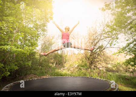 Teenager-Mädchen Sterne springen auf dem Trampolin, im Freien zu tun Stockfoto