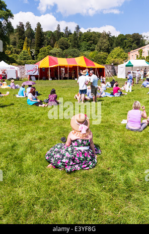 East Devon, England. Eine Frau sitzt auf dem Rasen beobachtete die Band Unternehmen B führen alte Glenn Miller Tunes aus dem 2. Weltkrieg. Stockfoto