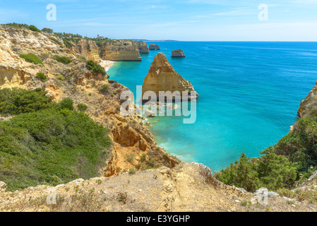 Gesamtansicht der weltbekannten Marinha Strand mit dem blauen Wasser und Felsvorsprüngen in Portugal. Stockfoto