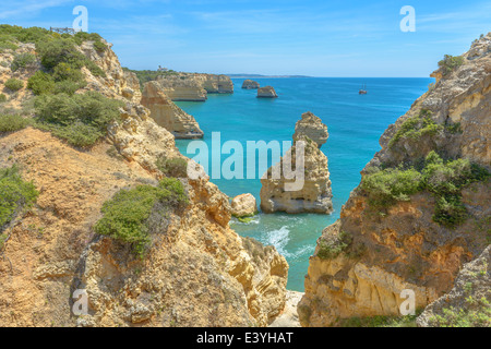 Gesamtansicht der weltbekannten Marinha Strand mit dem blauen Wasser und Felsvorsprüngen in Portugal. Stockfoto