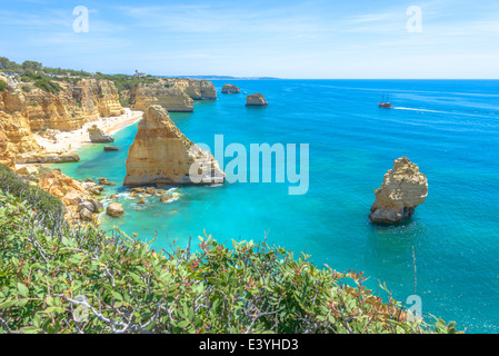 Gesamtansicht der weltbekannten Marinha Strand mit dem blauen Wasser und Felsvorsprüngen in Portugal. Stockfoto