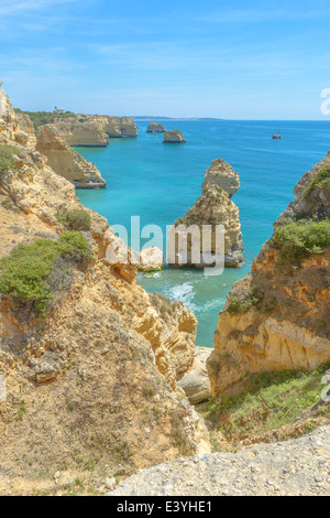 Gesamtansicht der weltbekannten Marinha Strand mit dem blauen Wasser und Felsvorsprüngen in Portugal. Stockfoto