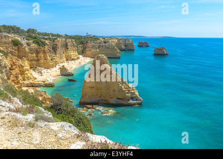 Gesamtansicht der weltbekannten Marinha Strand mit dem blauen Wasser und Felsvorsprüngen in Portugal. Stockfoto