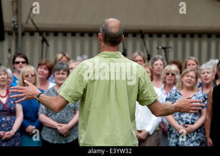 Ein Mann führt einen Gemeinschaft-Chor bei Leamington Peace Festival, UK Stockfoto